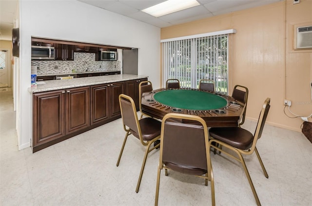 playroom with a paneled ceiling and an AC wall unit