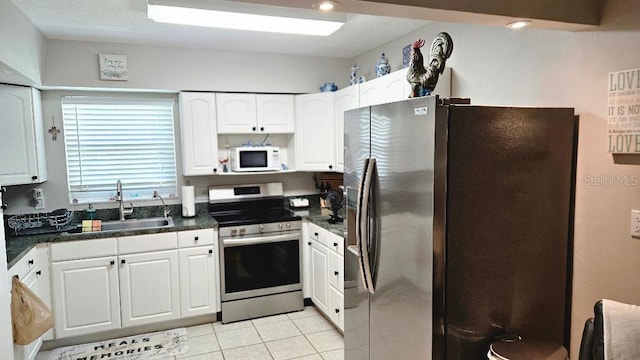 kitchen featuring white cabinets, appliances with stainless steel finishes, sink, and light tile patterned flooring