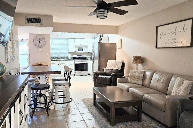 living room with ceiling fan and sink