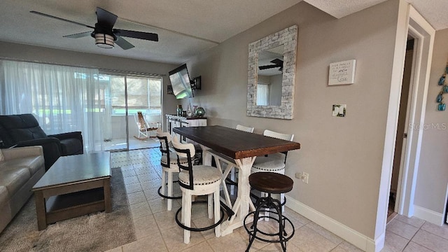 dining space with ceiling fan, light tile patterned floors, and a textured ceiling