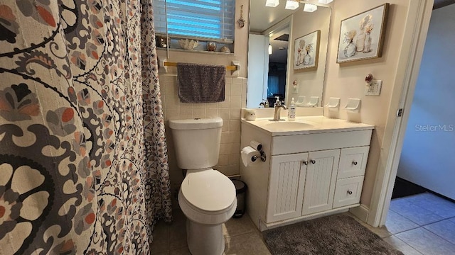 bathroom featuring vanity, toilet, tile walls, and tile patterned floors