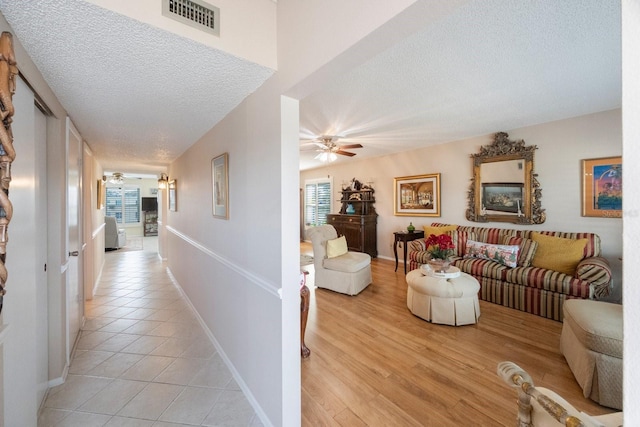 hallway featuring a textured ceiling and light wood-type flooring