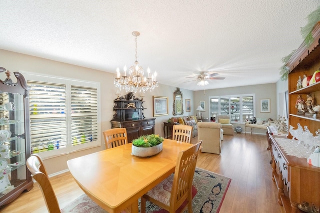 dining room featuring a textured ceiling, light hardwood / wood-style floors, and ceiling fan with notable chandelier