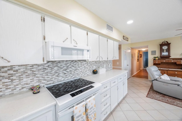 kitchen featuring tasteful backsplash, white cabinetry, white appliances, and light tile patterned floors