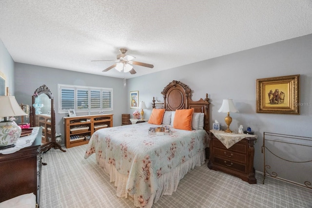 carpeted bedroom featuring a textured ceiling and ceiling fan