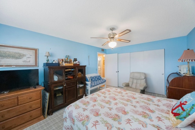 bedroom with ceiling fan and a textured ceiling