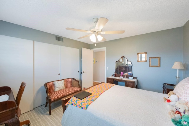 carpeted bedroom with a textured ceiling and ceiling fan