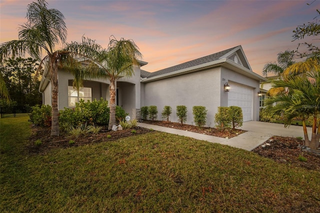 view of front facade with a garage and a lawn