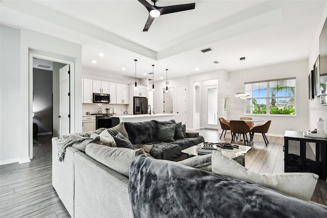 living room featuring ceiling fan and light hardwood / wood-style flooring