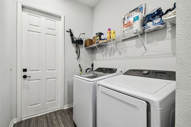 laundry room featuring dark hardwood / wood-style flooring and washing machine and dryer