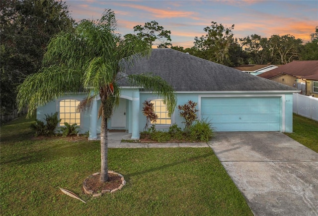 ranch-style home with a lawn and a garage