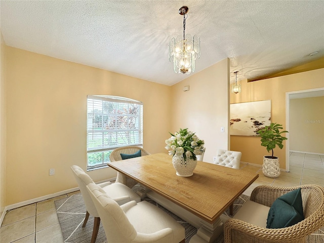 tiled dining area featuring a textured ceiling, an inviting chandelier, and lofted ceiling