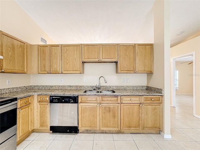 kitchen featuring light stone counters, appliances with stainless steel finishes, light tile patterned floors, sink, and vaulted ceiling