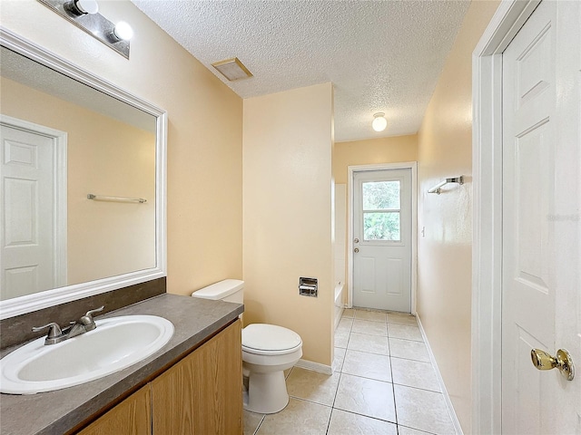 full bathroom with toilet, vanity, a textured ceiling, and tile patterned floors