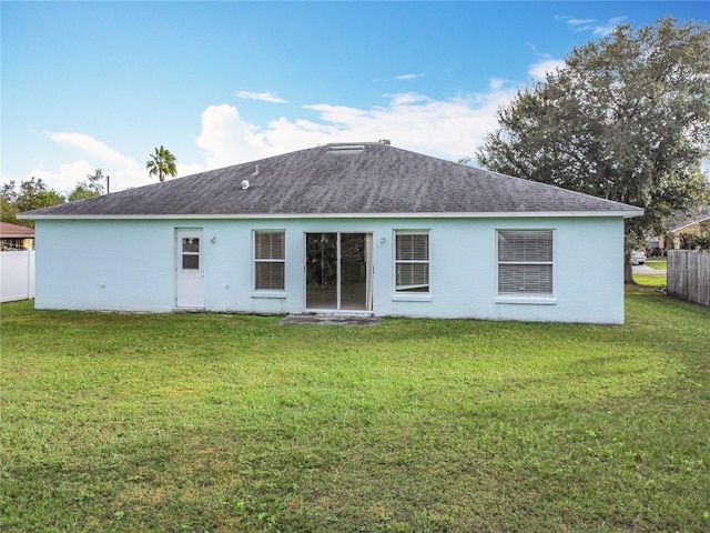 rear view of property with a yard