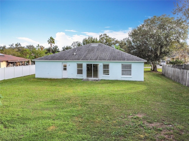 back of property featuring a lawn