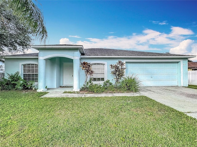 ranch-style home with a garage and a front lawn