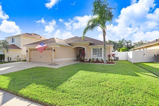 view of front of house with a garage, a front yard, and central AC