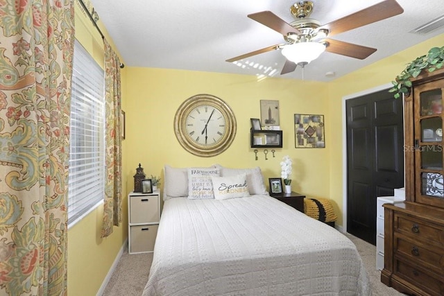 carpeted bedroom with multiple windows and ceiling fan