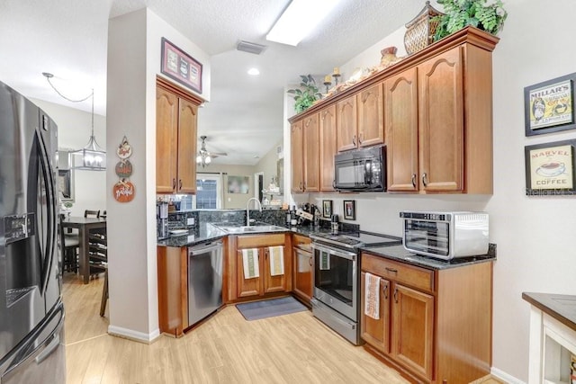 kitchen with light hardwood / wood-style floors, sink, appliances with stainless steel finishes, ceiling fan with notable chandelier, and a textured ceiling