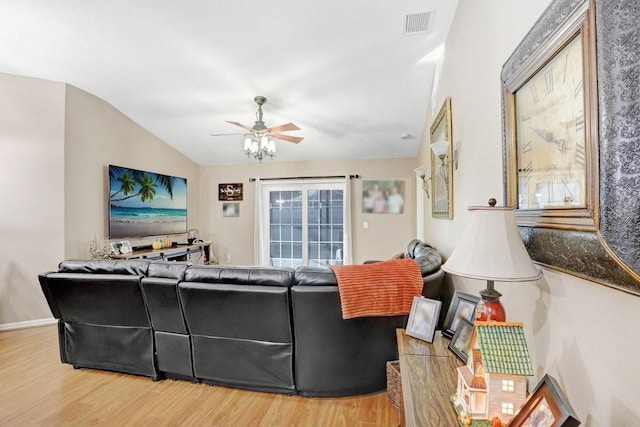 living room with hardwood / wood-style flooring, ceiling fan, and lofted ceiling