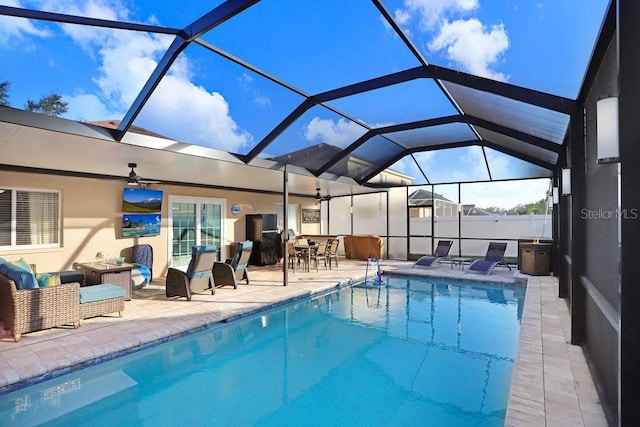 view of swimming pool with a lanai, ceiling fan, and a patio