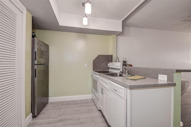 kitchen featuring white cabinets, sink, ceiling fan, light hardwood / wood-style flooring, and white appliances