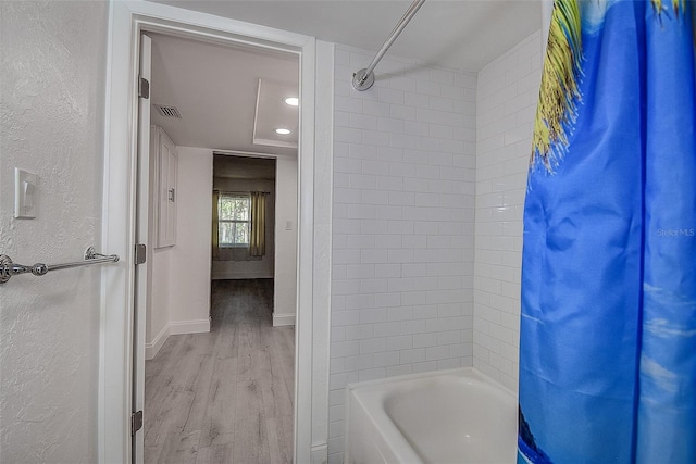 bathroom with shower / bath combo and wood-type flooring