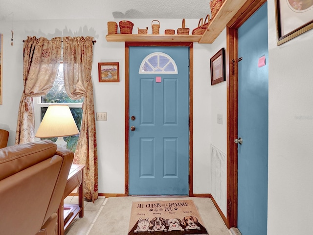 foyer entrance with a textured ceiling