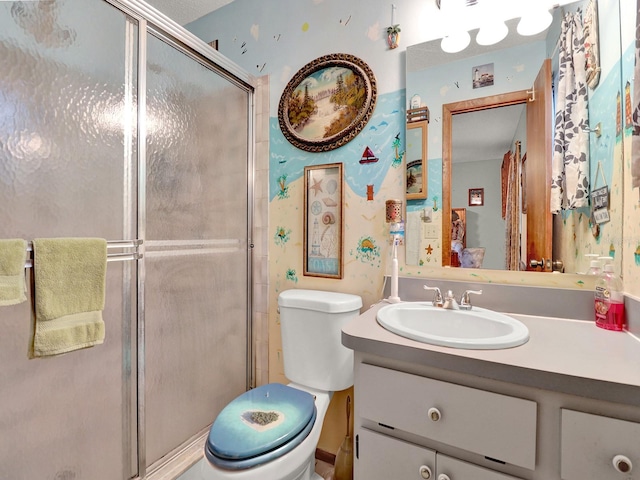 bathroom featuring a shower with shower door, vanity, and toilet