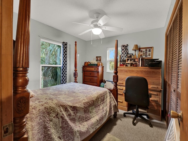 carpeted bedroom featuring ceiling fan, multiple windows, a closet, and a textured ceiling