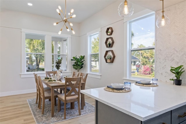 dining area with a healthy amount of sunlight, an inviting chandelier, and light hardwood / wood-style flooring