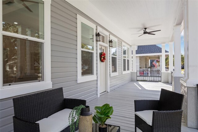 wooden terrace with ceiling fan and covered porch