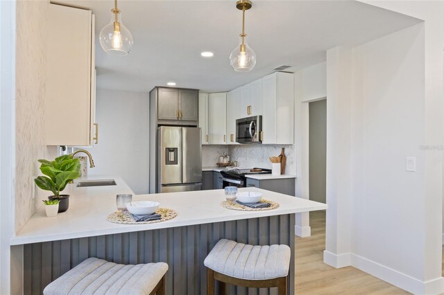 kitchen featuring pendant lighting, stainless steel appliances, and kitchen peninsula