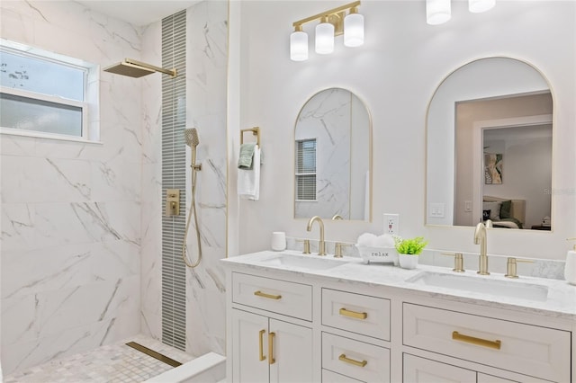 bathroom featuring tiled shower and vanity