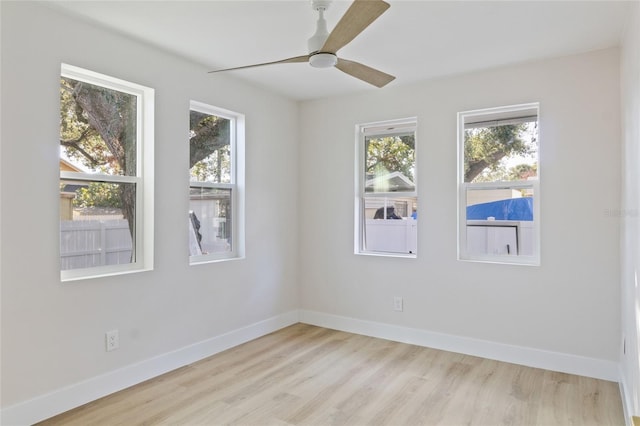 empty room with light hardwood / wood-style flooring, a wealth of natural light, and ceiling fan