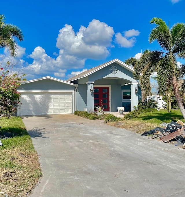 17082 Dolphin Dr, North Redington Beach, FL 33708 - view of front facade featuring concrete driveway, an attached garage, and stucco siding