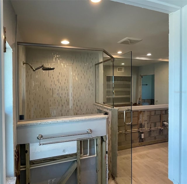 bathroom with hardwood / wood-style floors and walk in shower