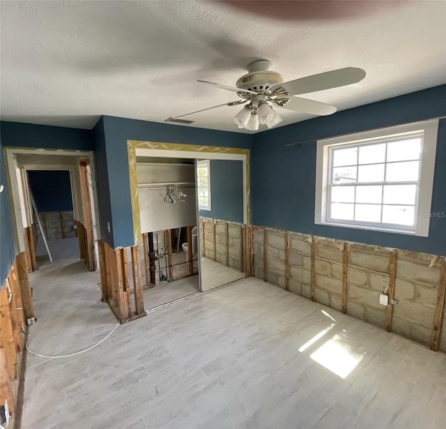 unfurnished room featuring ceiling fan, hardwood / wood-style floors, and a textured ceiling