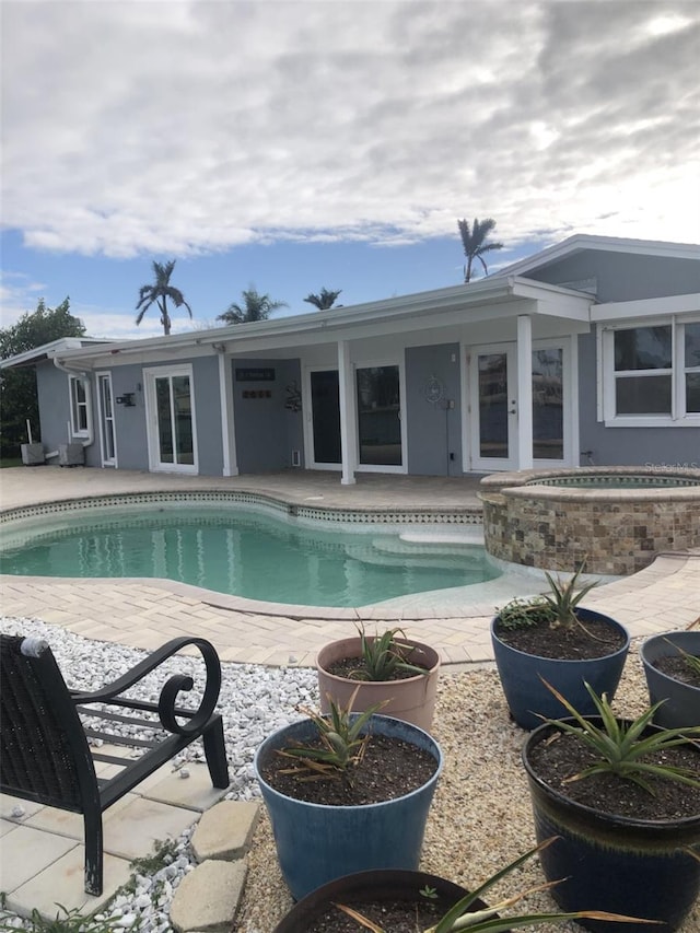 view of swimming pool with an in ground hot tub and a patio