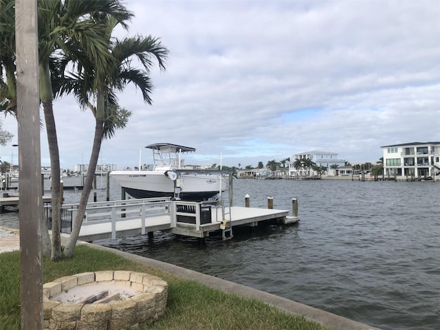 dock area with a water view and an outdoor fire pit