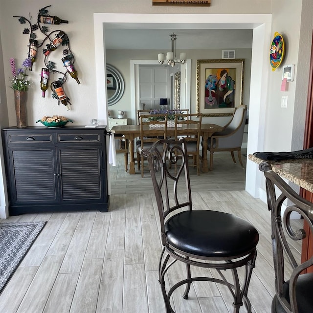 dining room featuring light wood-type flooring and a notable chandelier