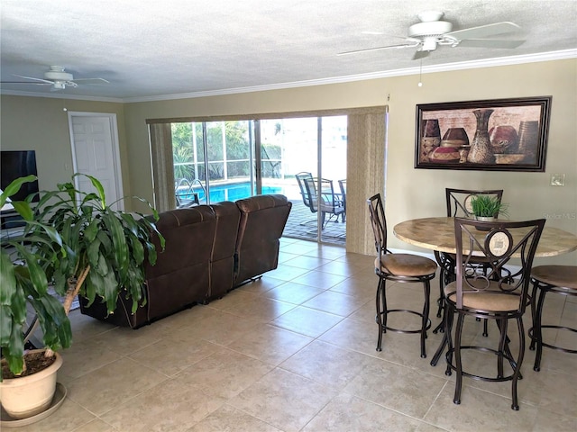 living room with ceiling fan, ornamental molding, and a textured ceiling