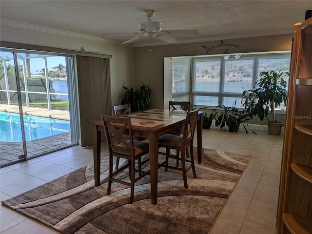 dining room featuring light tile patterned floors, a textured ceiling, a water view, and ceiling fan