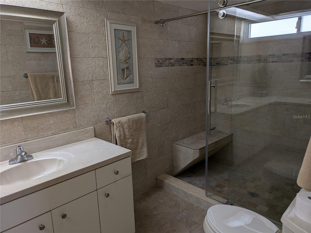 bathroom with vanity, toilet, an enclosed shower, and tile walls