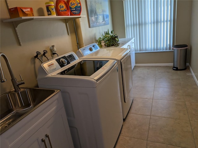 washroom featuring sink, light tile patterned floors, cabinets, and independent washer and dryer