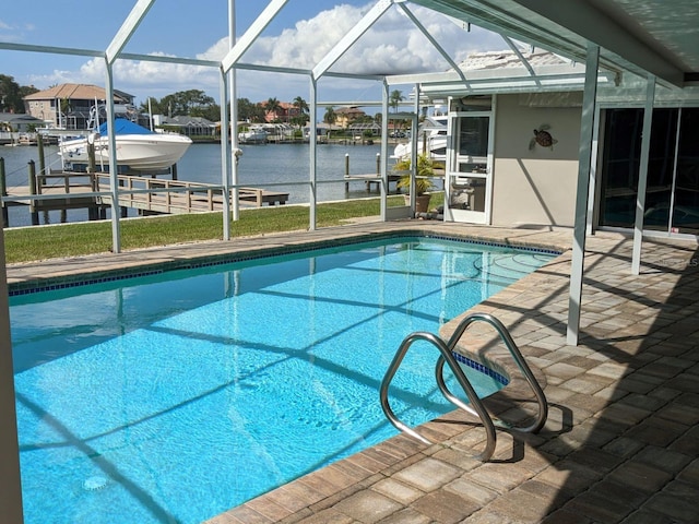 view of swimming pool with glass enclosure, a dock, a water view, and a patio