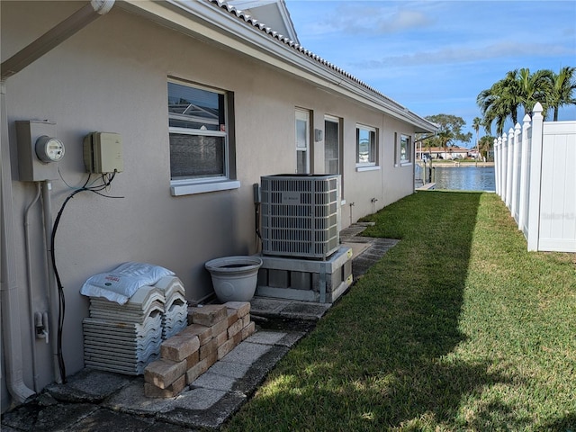 view of yard featuring a water view and central AC unit