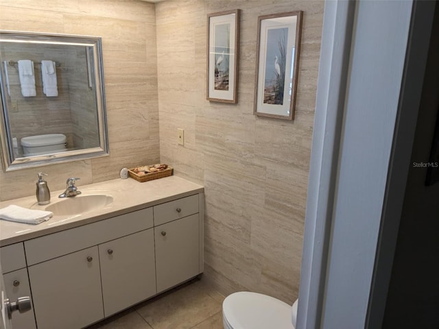 bathroom with tile patterned floors, vanity, toilet, and tile walls