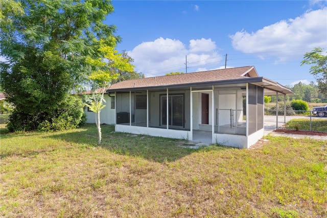 rear view of property with a lawn and a sunroom